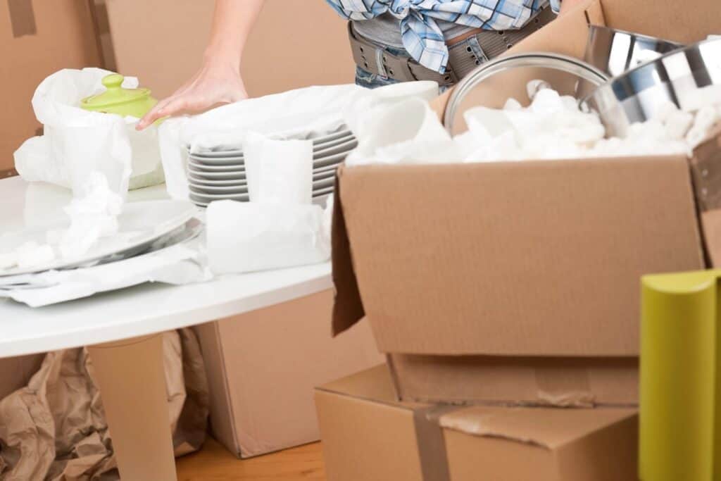 A woman's hand while unpacking the cardboard boxes