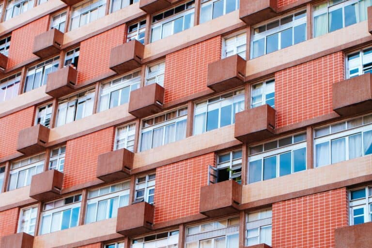 Cropped image of an apartment building with balconies in the concept of affordable housing options in East London.